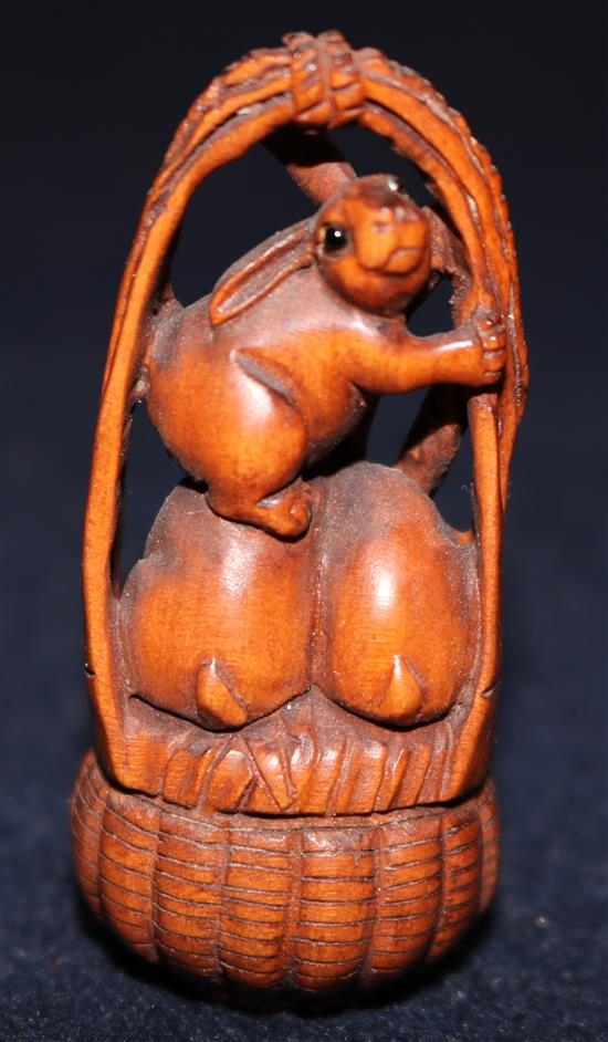 A Japanese carved boxwood netsuke of rabbits in a basket